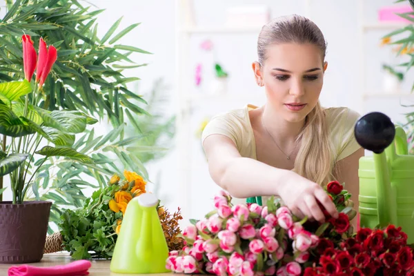 Mujer joven regando plantas en su jardín — Foto de Stock