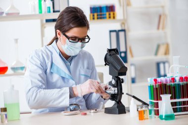 Laboratuar kimyageri güzellik ve makyaj ürünlerini kontrol ediyor.