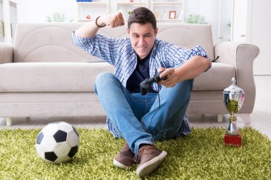 Genç adam evde bilgisayar oyunu oynuyor.