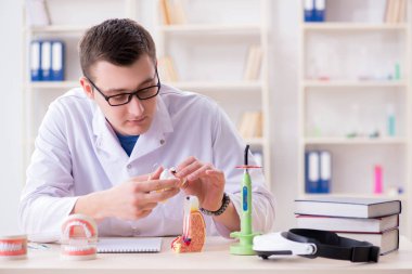 Tıp laboratuarına diş implantı yerleştiren dişçi.