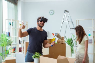 Sanal gözlüklü genç bir aile, Bo ile birlikte yeni evde bavullarını boşaltıyorlar.