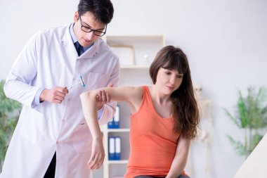 Doktor nörolog kadın hastayı muayene ediyor.