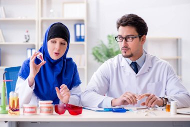 Diş hekimi ve asistanı yeni diş implantı üzerinde çalışıyor.