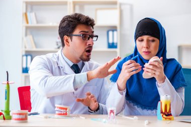 Diş hekimi ve asistanı yeni diş implantı üzerinde çalışıyor.