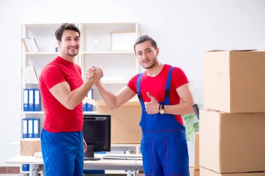 İki müteahhit personel kişisel eşyalarını taşıyor.