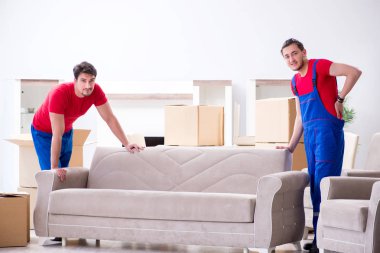 İki müteahhit personel kişisel eşyalarını taşıyor.