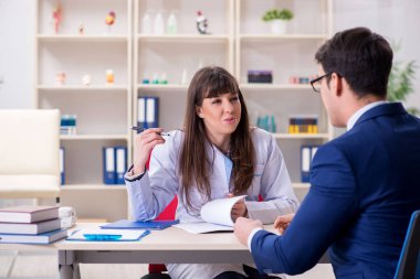 İş adamı doktorla sağlık sorunlarını tartışıyor