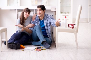 Erkek ve kadın evde mobilya montajı yapıyor.