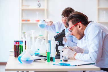 Laboratuvarda çalışan kimyagerler.