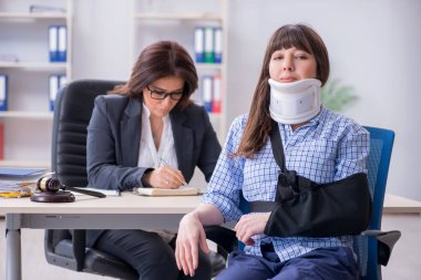 Injured employee visiting lawyer for advice on insurance clipart