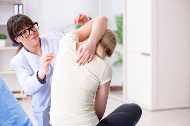 Doktor goniyometre ile eklem esnekliğini kontrol ediyor