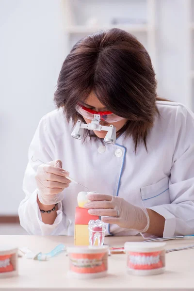 Mujer dentista trabajando en implantes dentales — Foto de Stock