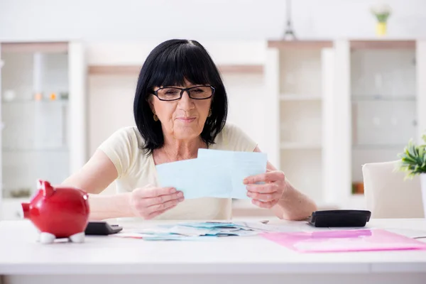 Reife Frau versucht, ihre Rechnungen unter einen Hut zu bringen — Stockfoto