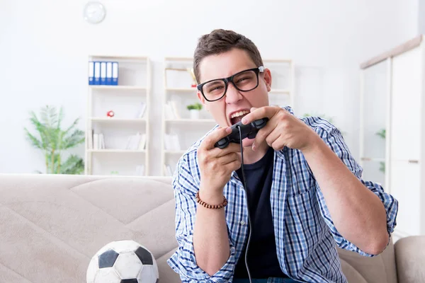 Молодой человек играет в компьютерные игры дома — стоковое фото