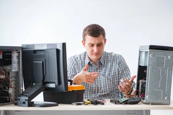Молодий технік ремонтує комп'ютер в майстерні — стокове фото