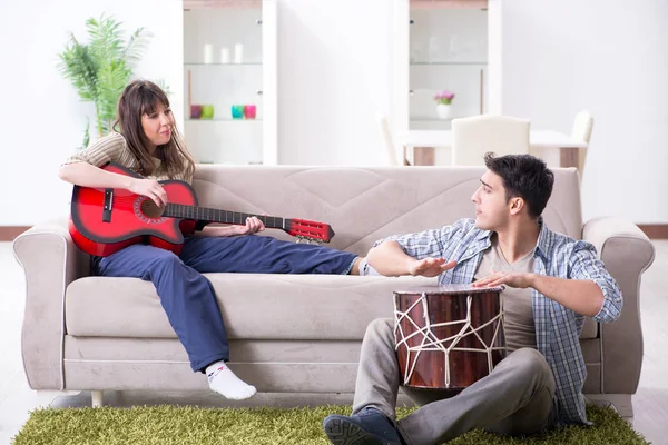 Jonge familie die thuis muziek zingt en speelt — Stockfoto