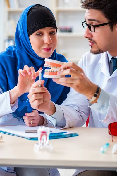 Médecin dentiste et assistant travaillant sur un nouvel implant dentaire — Photo