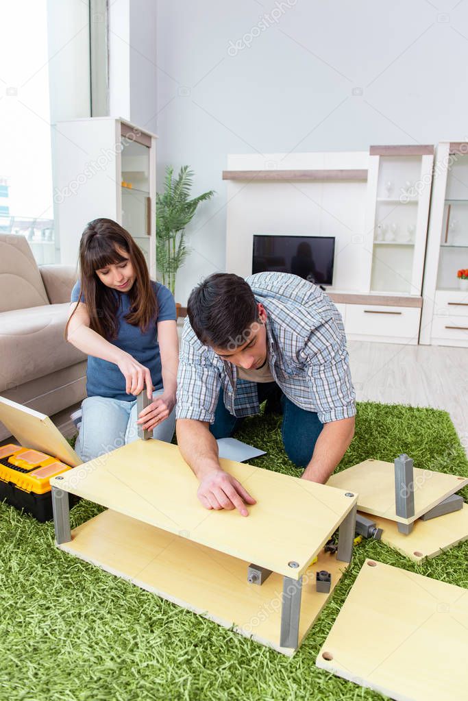 Young family assembling furniture at new house