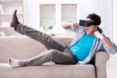 Eli yaralı bir adam sanal gerçeklik gözlüğü takıyor.