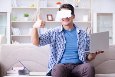 Evde sanal gerçeklik gözlükleriyle serbest çalışan bir öğrenci.