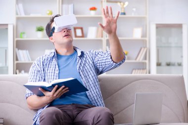 Evde sanal gerçeklik gözlükleriyle serbest çalışan bir öğrenci.