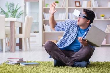 Evde sanal gerçeklik gözlükleriyle serbest çalışan bir öğrenci.