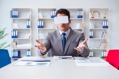 Ofiste sanal gerçeklik gözlüklü bir iş adamı var.