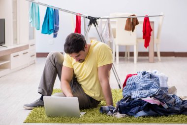 Yakışıklı koca evde çamaşır yıkıyor.