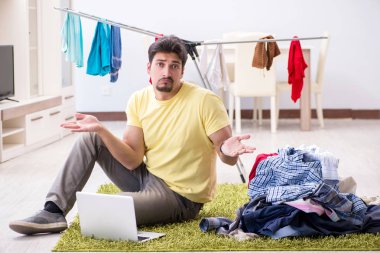 Yakışıklı koca evde çamaşır yıkıyor.