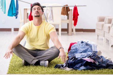 Yakışıklı koca evde çamaşır yıkıyor.