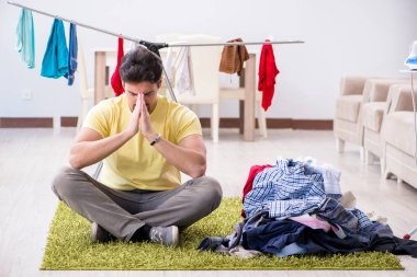 Yakışıklı koca evde çamaşır yıkıyor.