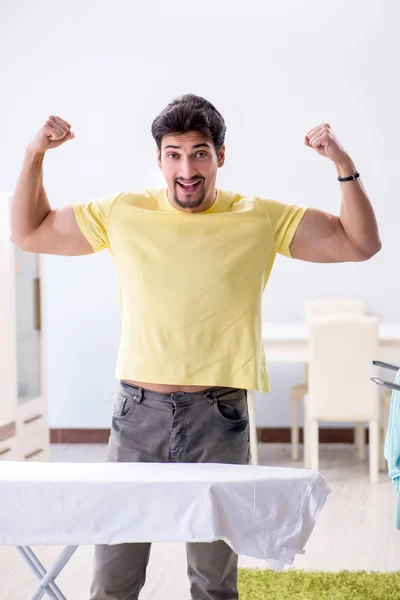 Bello uomo marito fare abbigliamento stiratura a casa — Foto Stock