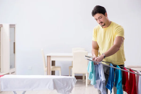 Bonito marido fazendo lavagem em casa — Fotografia de Stock