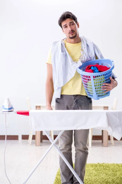 Knappe man man doet kleding strijken thuis — Stockfoto