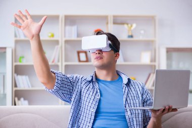 Evde sanal gerçeklik gözlükleriyle serbest çalışan bir öğrenci.
