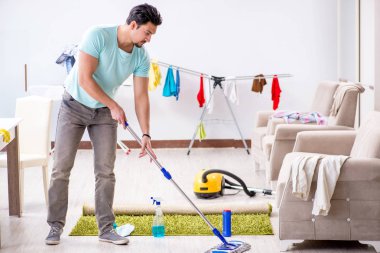 Genç ve çekici koca evde temizlik yapıyor.