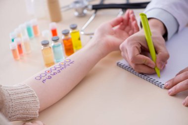 Hastanedeki hastanın alerji reaksiyonunu test eden doktor.