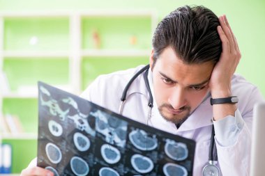 Doktor radyoloji uzmanı hastanede röntgen taramasına bakıyor.