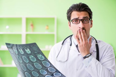 Doktor radyoloji uzmanı hastanede röntgen taramasına bakıyor.