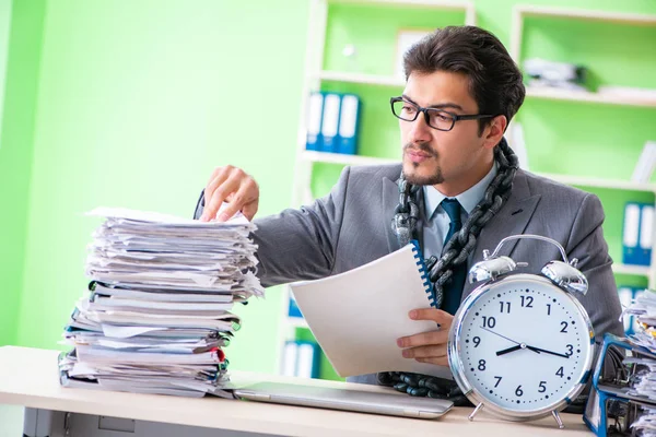 Employé enchaîné à son bureau en raison de la charge de travail — Photo