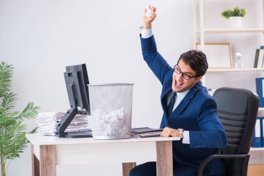 Genç ve yakışıklı bir işadamı büroda çalışıyor.