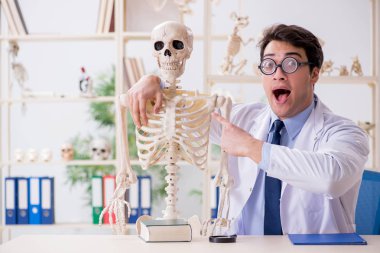 Çılgın profesör insan iskeleti üzerinde çalışıyor.