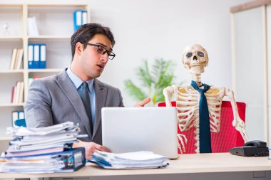 İskeletle çalışan bir iş adamı.