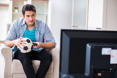 Evde televizyon izleyen bir adam.