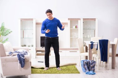 Genç adam çamaşırhane için kirli çamaşır topluyor.