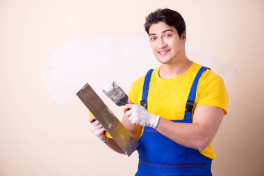 Duvara alçı yapıştıran genç müteahhit.