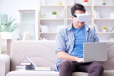 Evde sanal gerçeklik gözlükleriyle serbest çalışan bir öğrenci.