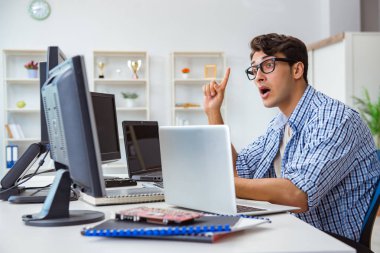 Birçok ekranın önünde oturan bir iş adamı