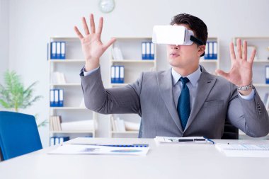Ofiste sanal gerçeklik gözlüklü bir iş adamı var.