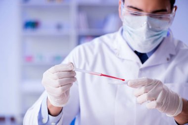 Laboratuvar asistanı hastanede kan örneklerini test ediyor.